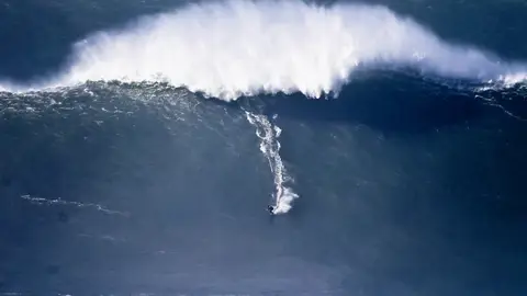 Surfista en la playa lusa de Nazaré Surfista en la playa lusa de Nazaré