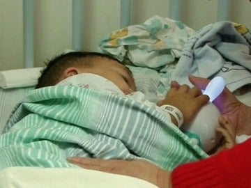  Un niño chino de tres años a la espera de recibir tratamiento médico después de beber ácido sulfurico