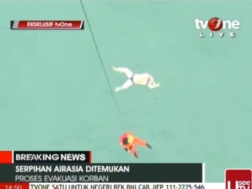 Un operario baja a rescatar un cuerpo de una víctima del avión de AirAsia