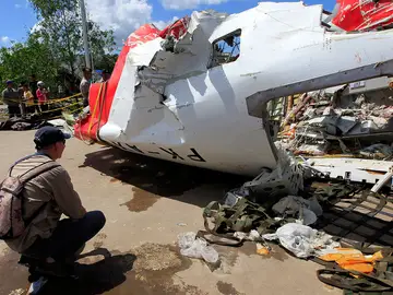 Un investigador inspecciona los restos del avión de AirAsia Un investigador inspecciona los restos del avión de AirAsia