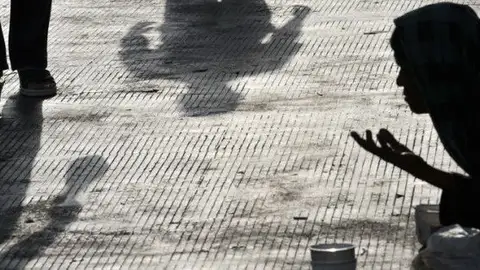 Imagen de recurso de una persona sin hogar Un mendigo pidiendo limosna