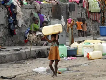 Una niña huérfana carga con un bidón para el agua en Bombai (India). Una niña huérfana carga con un bidón para el agua en Bombai (India).