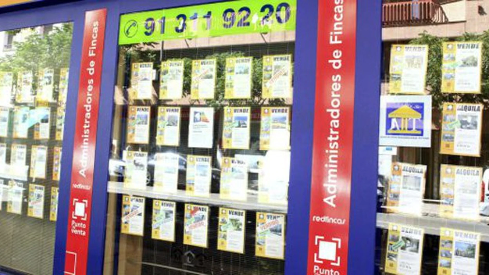 Un escaparate de una inmobiliaria en Madrid, con anuncios de pisos en venta. Un escaparate de una inmobiliaria en Madrid, con anuncios de pisos en venta.