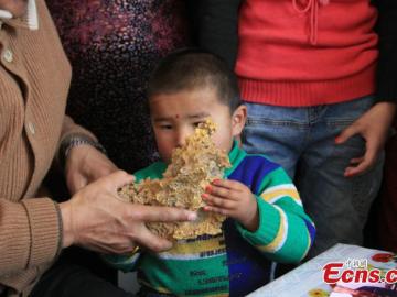 Un niño sostiene la pepita de oro