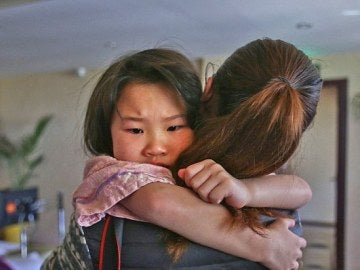 La pequeña Siyao en brazos de una empleada