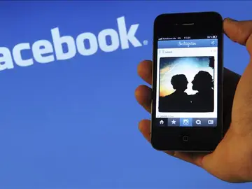 Un teléfono con el fondo del logo de Facebook Un teléfono con el fondo del logo de Facebook