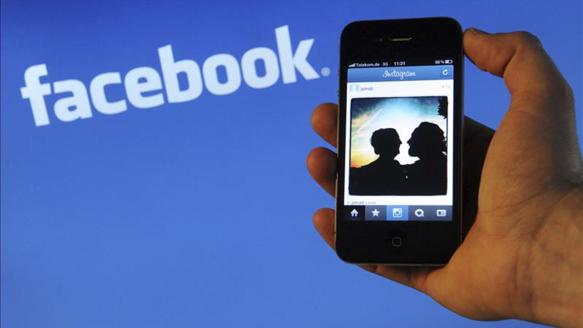 Un tel&eacute;fono con el fondo del logo de Facebook