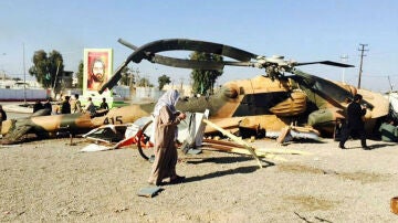 Sodados iraquíes revisan un helicóptero abatido en confrontaciones con EI