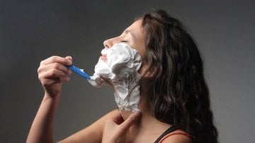 Una mujer se afeita con una maquinilla desechable.