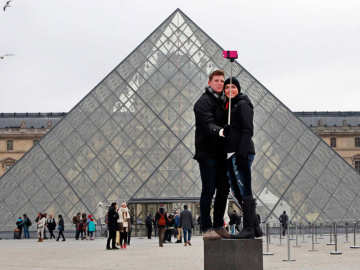 Pareja usando un palo de selfi en el Louvre