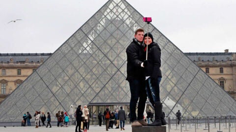 Pareja usando un palo de selfi en el Louvre