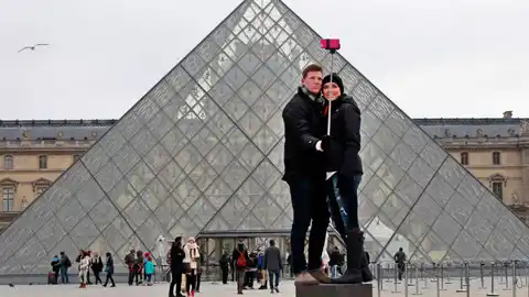 Pareja usando un palo de selfi en el Louvre Pareja usando un palo de selfi en el Louvre