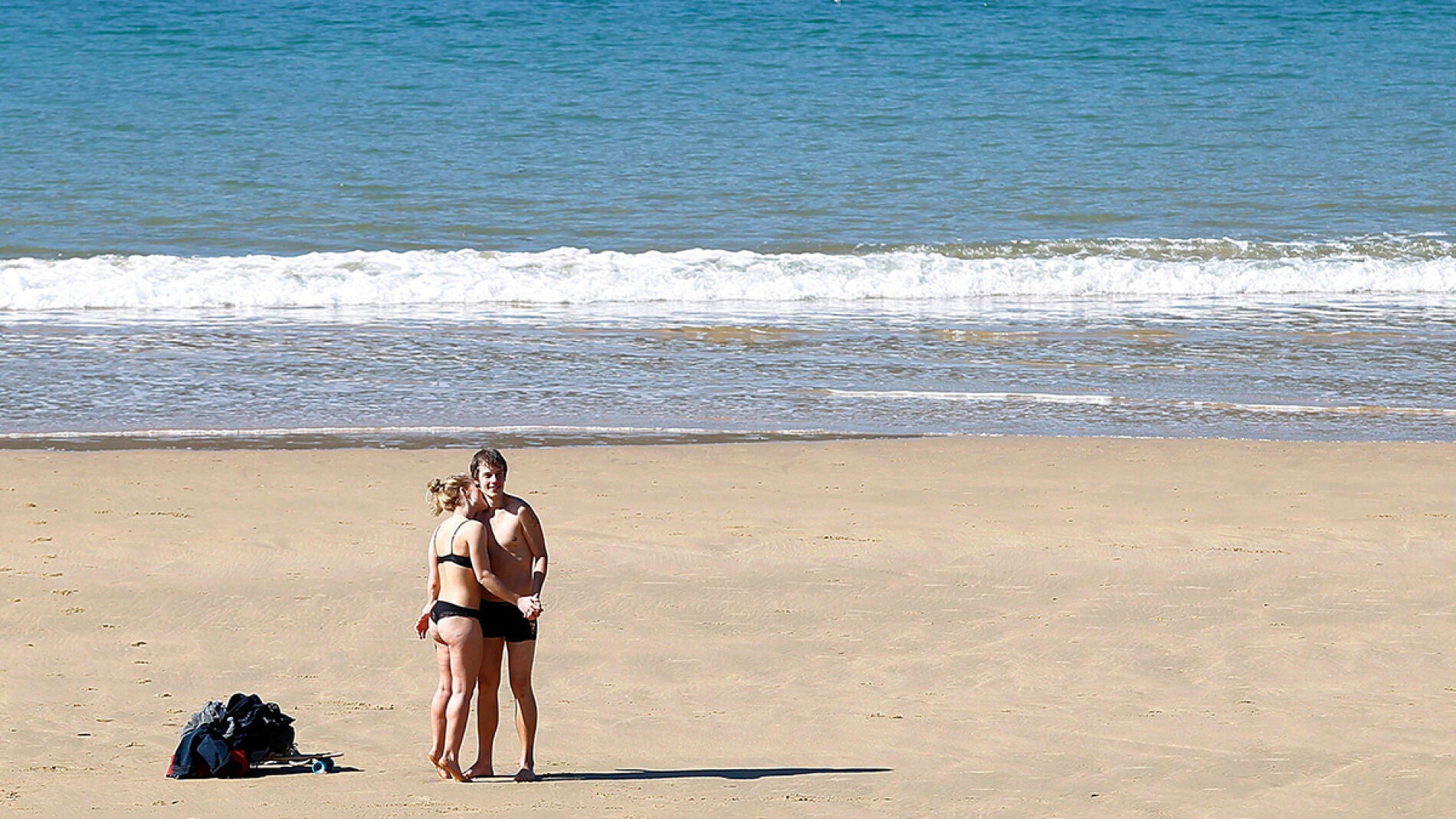 Una pareja disfruta del sol en la playa de La Concha de San Sebasti&aacute;n