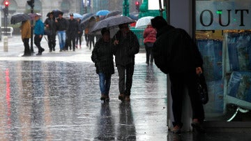Dos personas pasean bajo la lluvia en San Sebastián