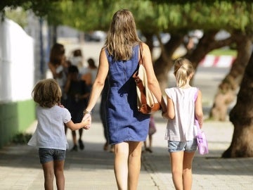 Una madre paseando con sus dos hijos