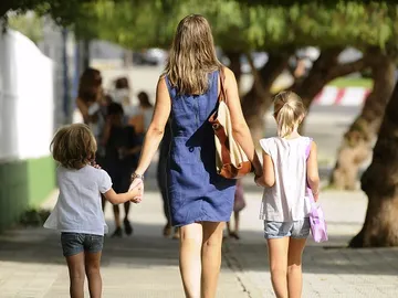 Una madre paseando con sus dos hijos Una madre paseando con sus dos hijos