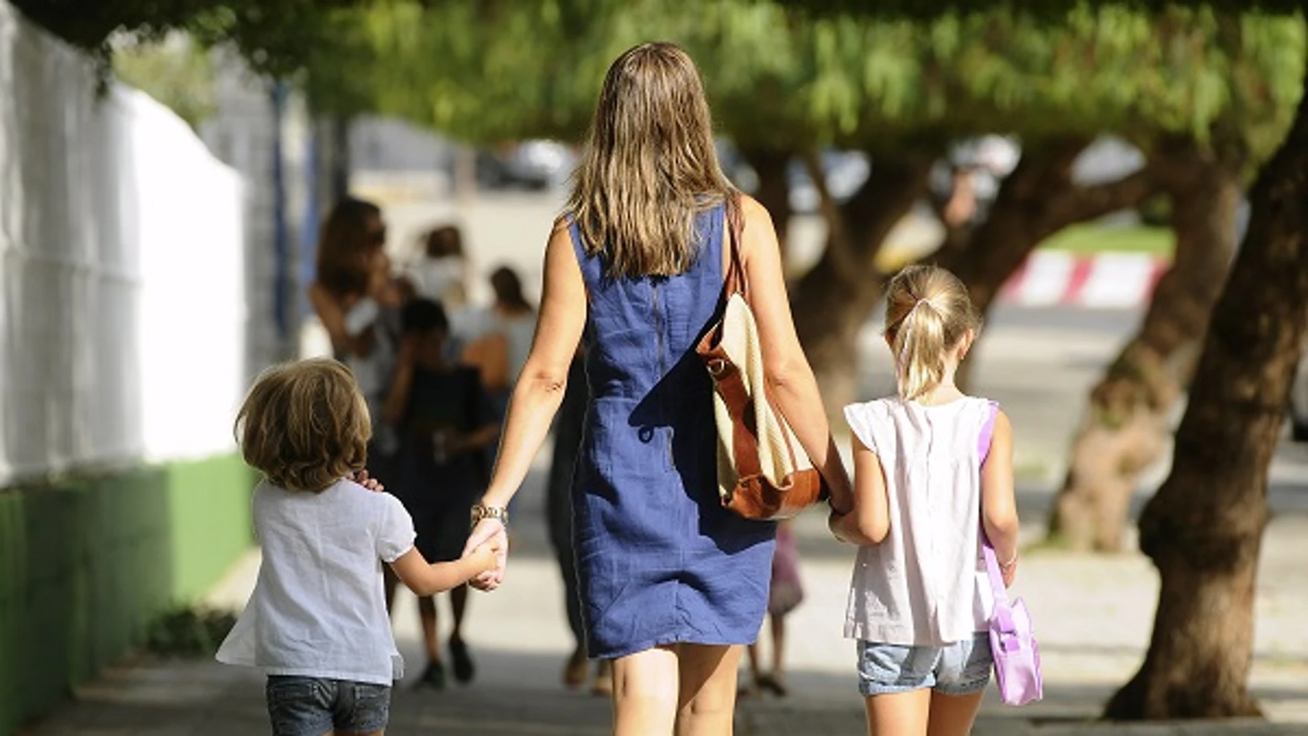 Una madre paseando con sus dos hijos Una madre paseando con sus dos hijos