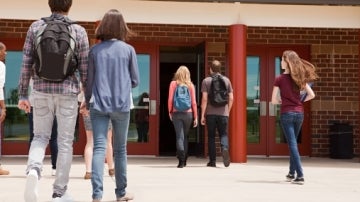 Una pareja de adolescentes entrando al instituto