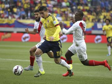 James Rodríguez conduce el balón ante dos rivales peruanos