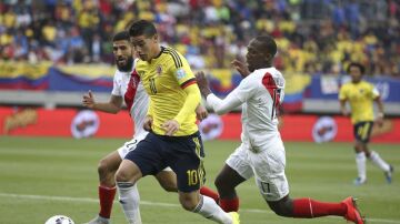 James Rodríguez conduce el balón ante dos rivales peruanos