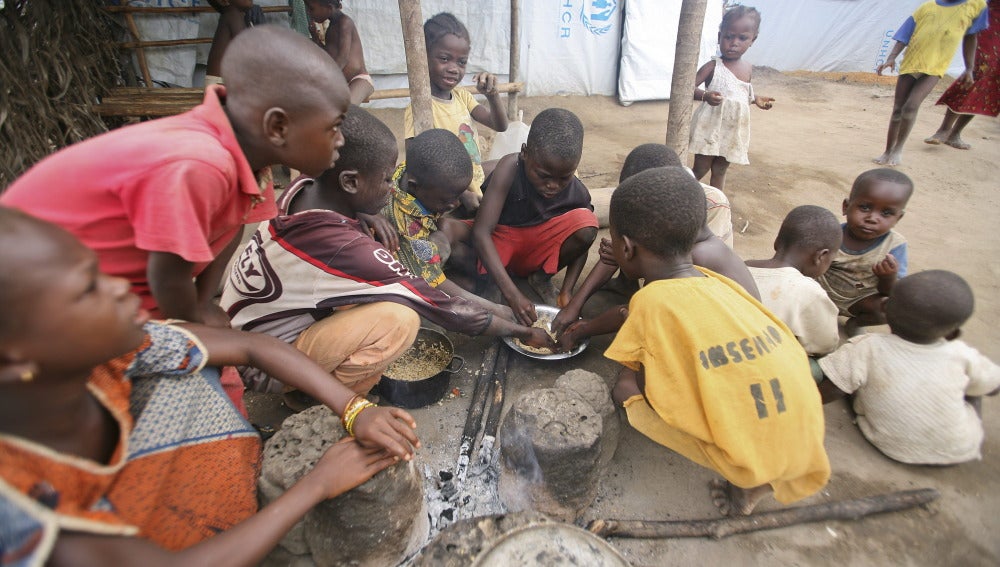 Niños marfileños comen en el campamento de refugiados de Bahn
