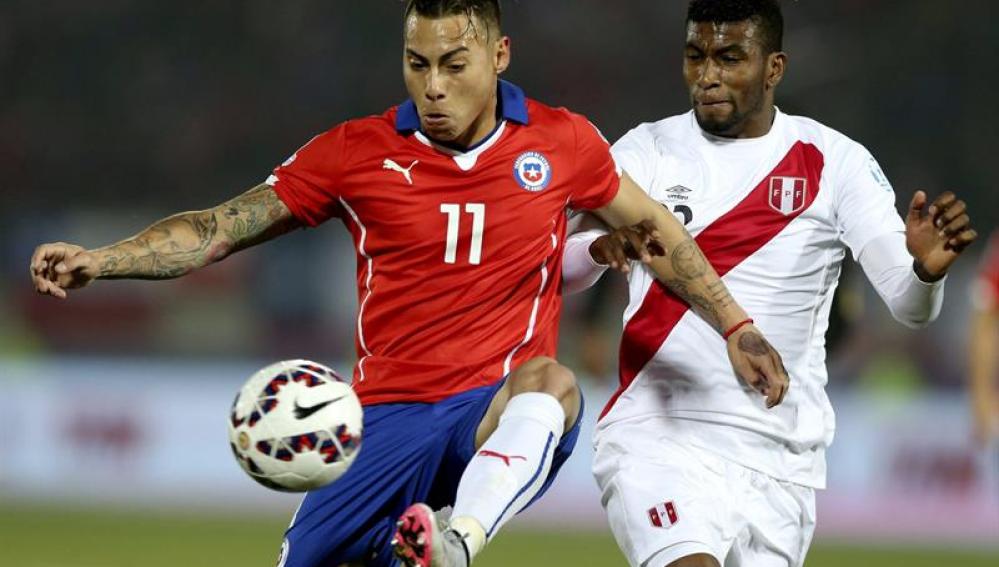 El delantero chileno Eduardo Vargas ante el centrocampista peruano Carlos Antonio Ascues.