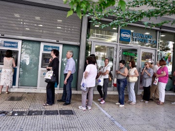 Ciudadanos griegos tratan de sacar dinero en un cajero de Atenas