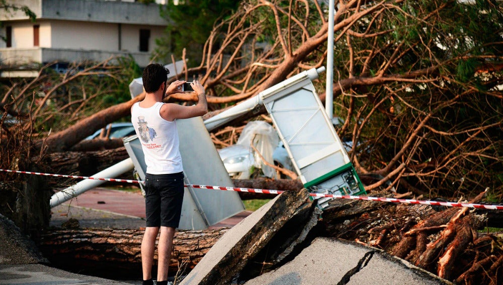 Un hombre toma fotografías de los daños causados por una tormenta en Cazzago di Pianiga, cerca de Venecia