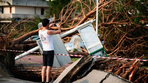 Un hombre toma fotograf&iacute;as de los da&ntilde;os causados por una tormenta en Cazzago di Pianiga, cerca de Venecia