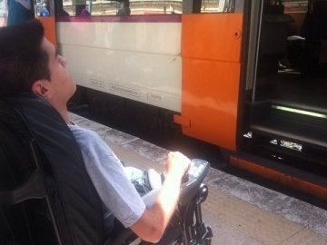 El joven en su silla de ruedas esperando a un tren de Renfe El joven en su silla de ruedas esperando a un tren de Renfe