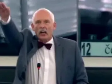 Janusz Korwin-Mikke, en el momento en que realiza el saludo nazi. Janusz Korwin-Mikke, en el momento en que realiza el saludo nazi.