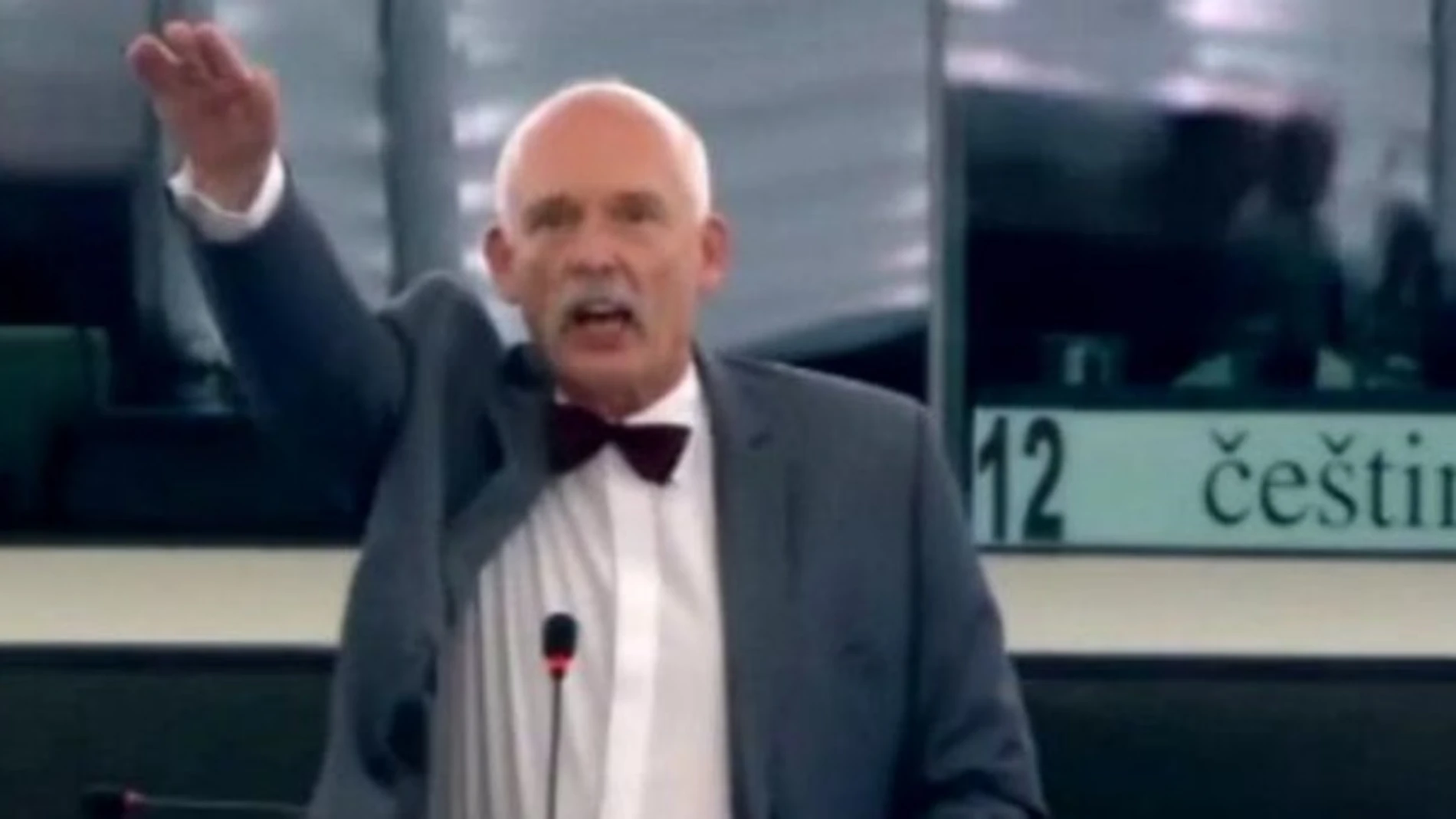 Janusz Korwin-Mikke, en el momento en que realiza el saludo nazi. Janusz Korwin-Mikke, en el momento en que realiza el saludo nazi.