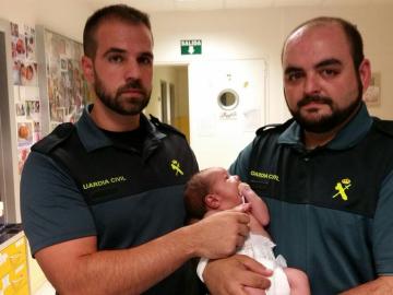 Los dos guardias civiles con la bebé encontrada en un contenedor en Madrid