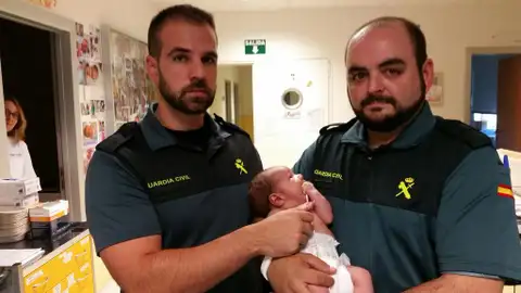 Los dos guardias civiles con la bebé encontrada en un contenedor en Madrid Los dos guardias civiles con la bebé encontrada en un contenedor en Madrid