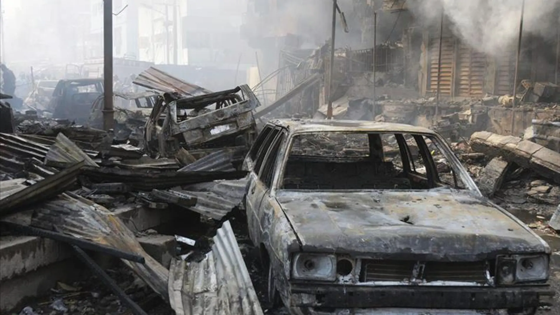 Escombros y coches calcinados por una explosión. Escombros y coches calcinados por una explosión.