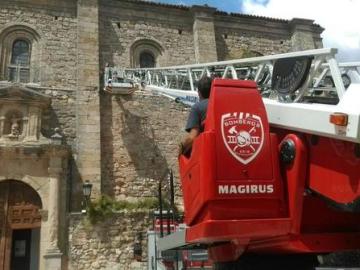 Bomberos colaborando en la retirada del artefacto en la Iglesia Atienza