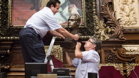 Dos operarios municipales retiran ayer el busto del Rey Juan Carlos I