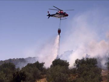 Un avion contra incendios hace una descarga sobre el fuego