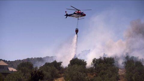Un avion contra incendios hace una descarga sobre el fuego