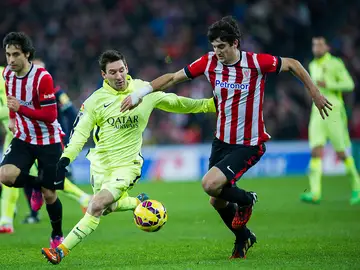 San José protege el balón ante la presión de Leo Messi San José protege el balón ante la presión de Leo Messi