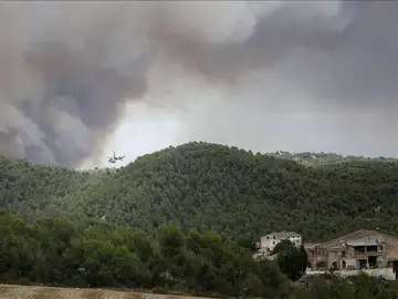 Un helicóptero trabaja cerca de varias viviendas para combatir el incendio Un helicóptero trabaja cerca de varias viviendas para combatir el incendio