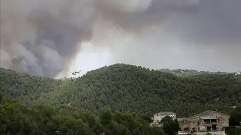 Un helicóptero trabaja cerca de varias viviendas para combatir el incendio Un helicóptero trabaja cerca de varias viviendas para combatir el incendio