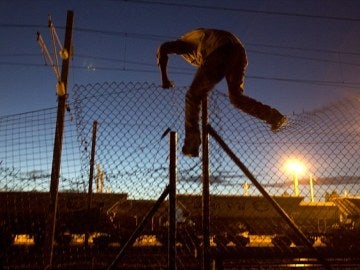 Inmigrante saltando una verja del Eurotunnel