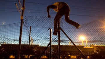 Inmigrante saltando una verja del Eurotunnel