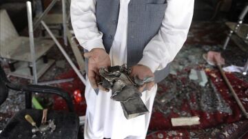 Un hombre muestra restos de objetos que han quedado tras la explosión