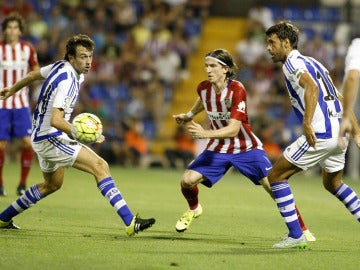 Filipe Luis conduce el balón ante la presión rival