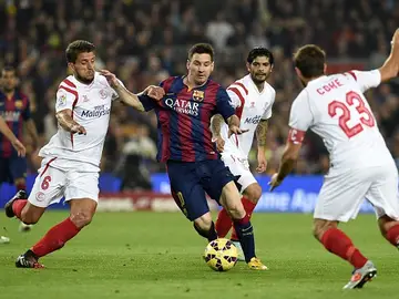 Messi lucha con tres defensas del Sevilla Messi lucha con tres defensas del Sevilla