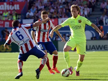 Rakitic maneja el balón ante la defensa de Koke y Siqueira Rakitic maneja el balón ante la defensa de Koke y Siqueira