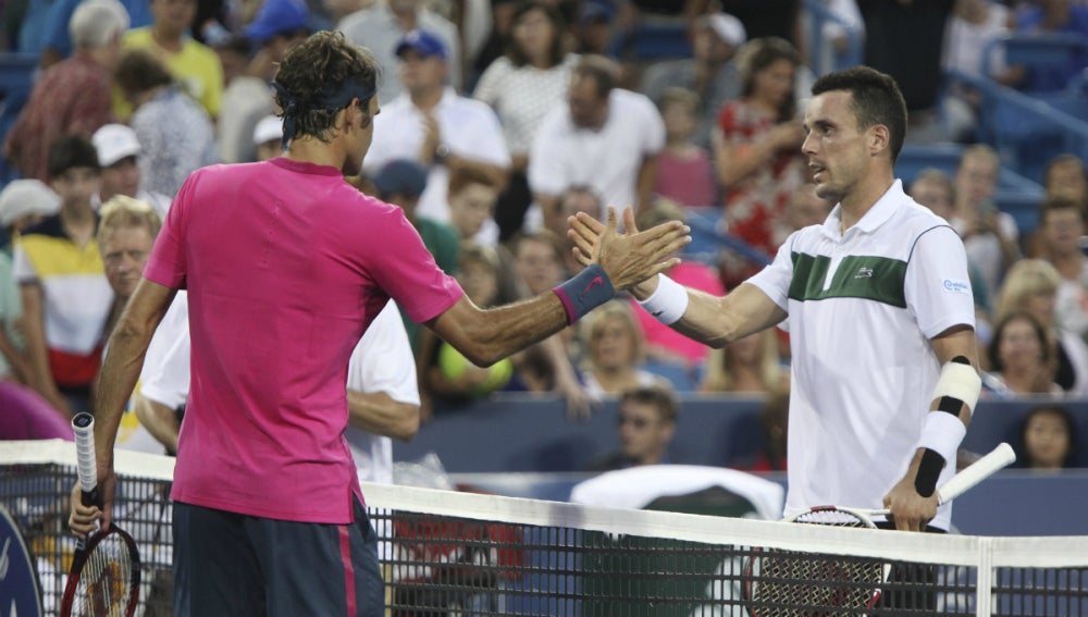 Roger Federer y Roberto Bautista, tras acabar su partido