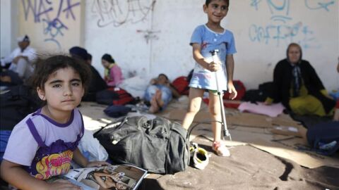 Ni&ntilde;os esperan para ser registrados en un campo de migrantes (Archivo)